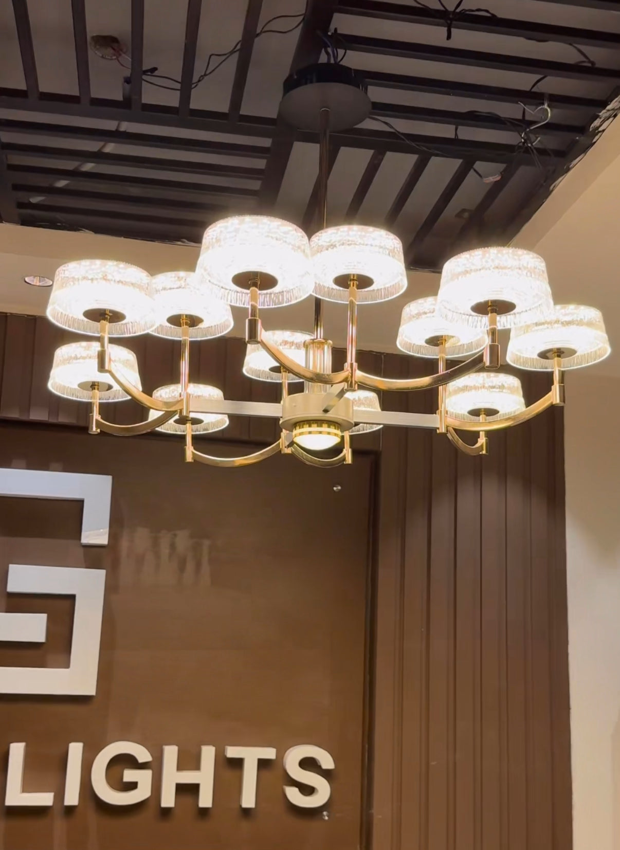Chandelier hanging in a room with a 'LIGHTS' sign in the background