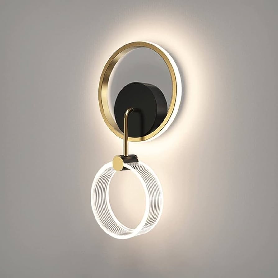 Modern wall light fixture with gold and black design on a gray background