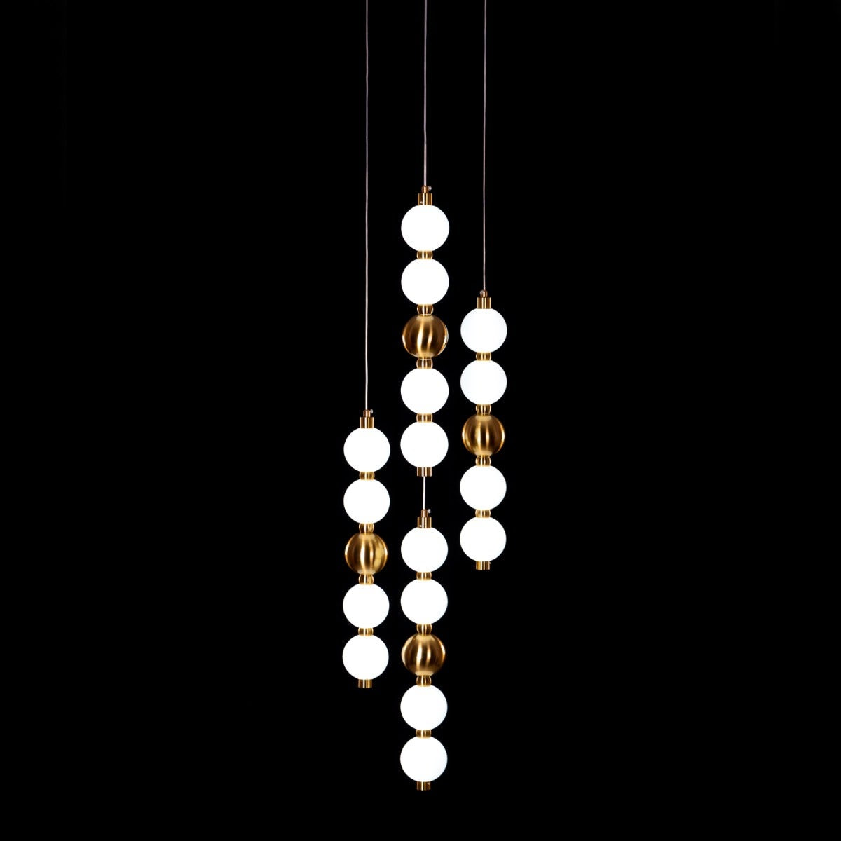 Modern pendant light with white and gold spherical bulbs on a black background