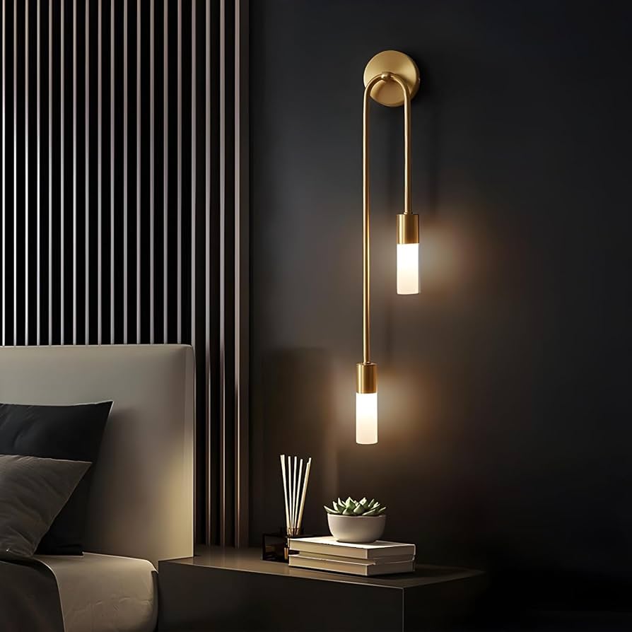Modern wall sconce in a bedroom setting with a dark wall and striped curtain.