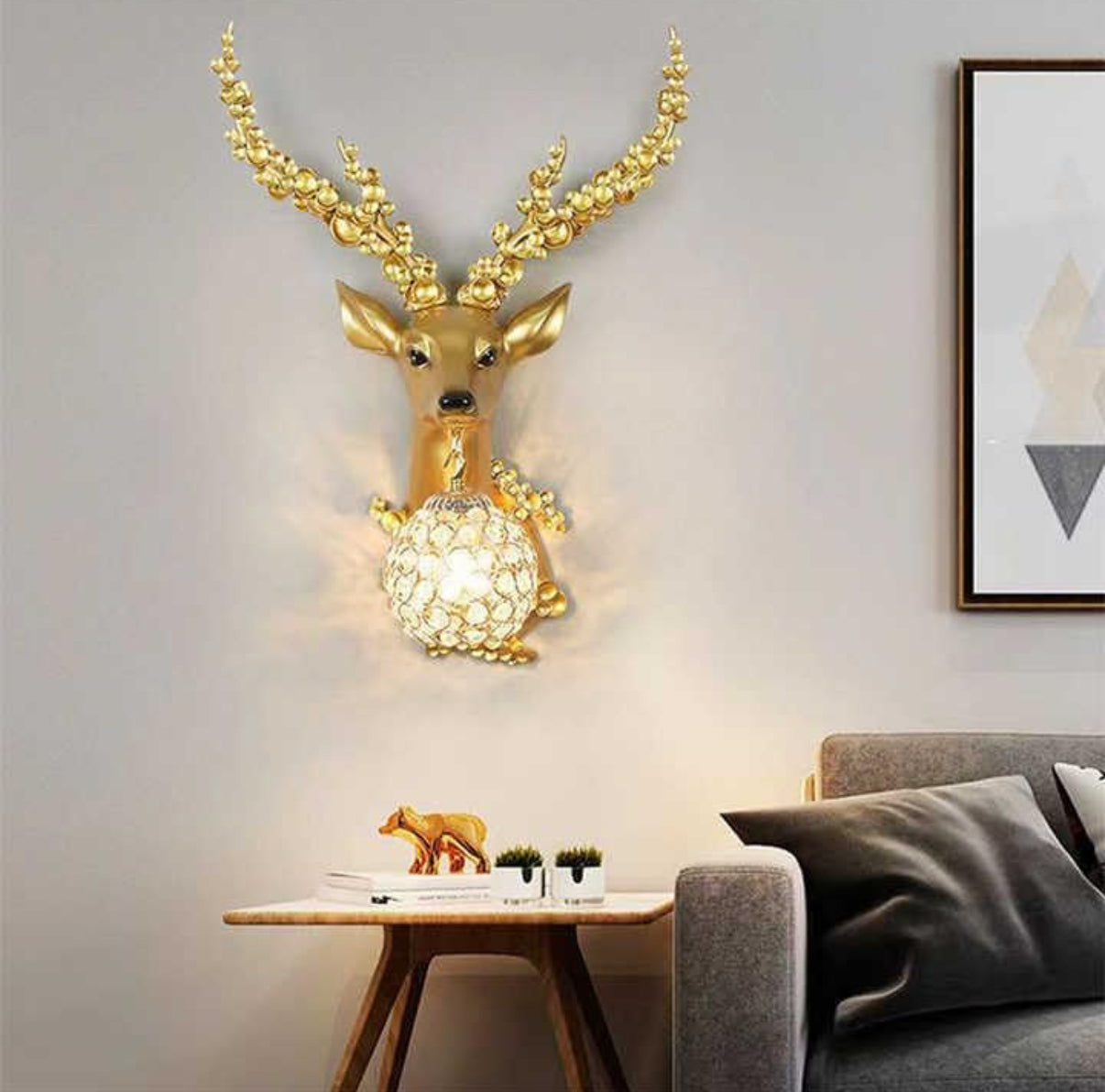 Decorative wall lamp shaped like a deer head with a glowing light bulb in a living room setting.