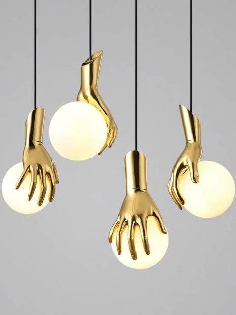 Gold hand-shaped pendant lights on a gray background