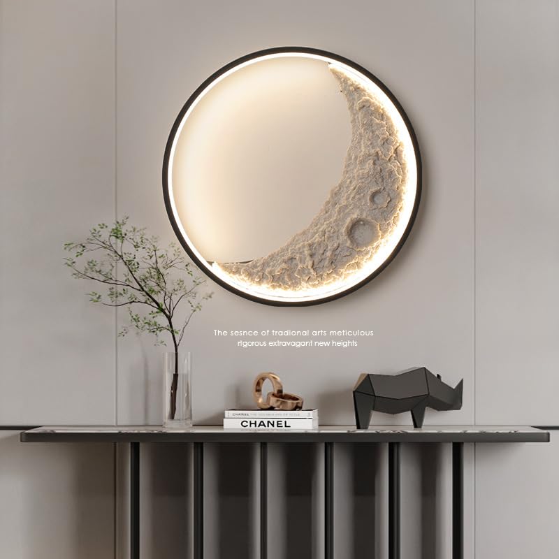 Decorative wall mirror with moon design on a gray wall above a console table.