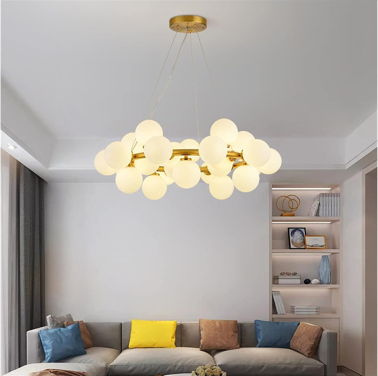 Modern living room with a stylish chandelier, gray sofa, and bookshelf.