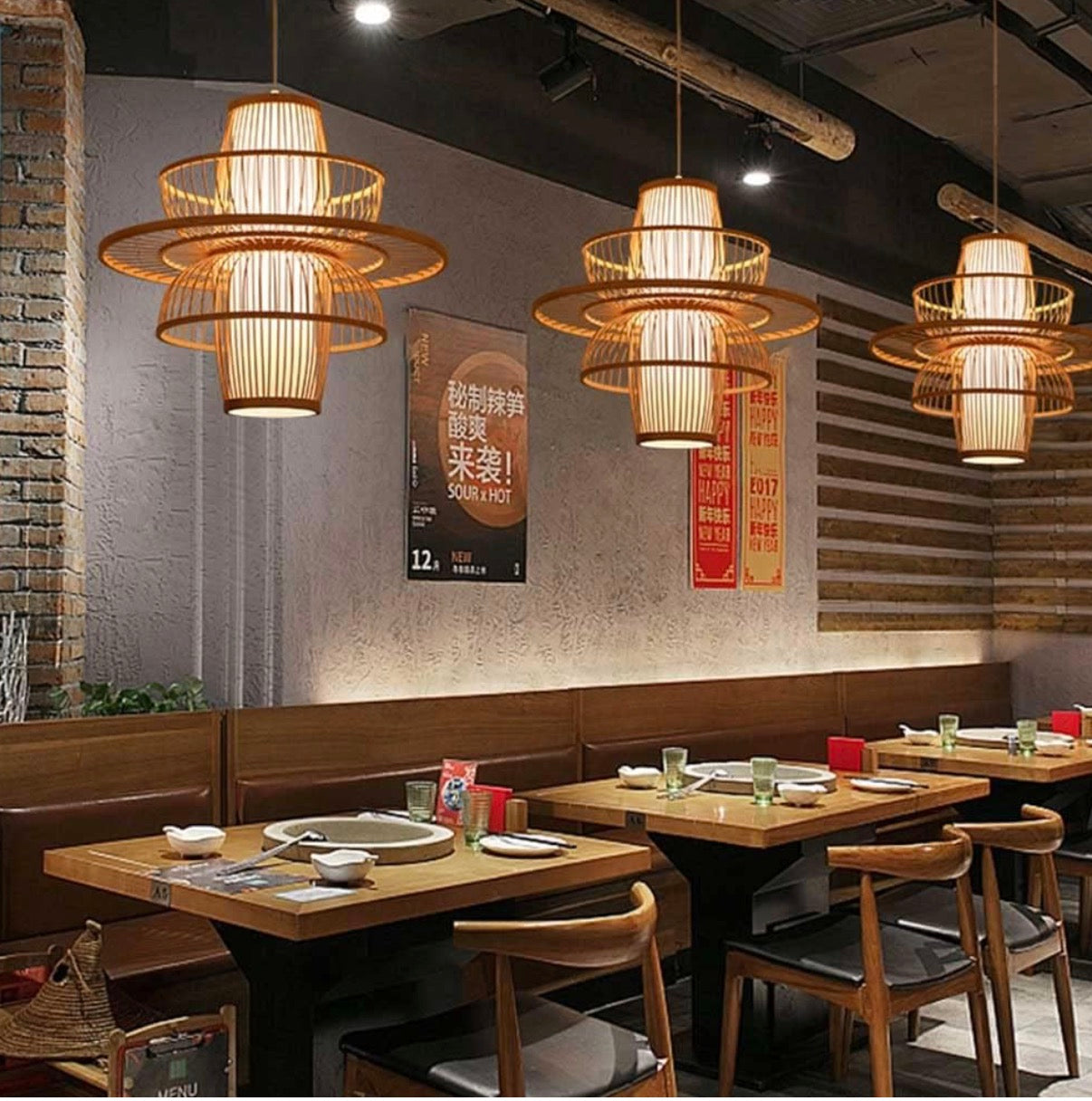 Dining area with wooden tables, chairs, and hanging lights in a restaurant setting.