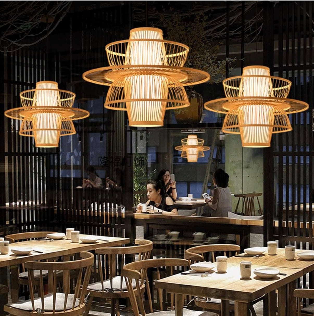 Restaurant interior with wooden tables, chairs, and decorative pendant lights.