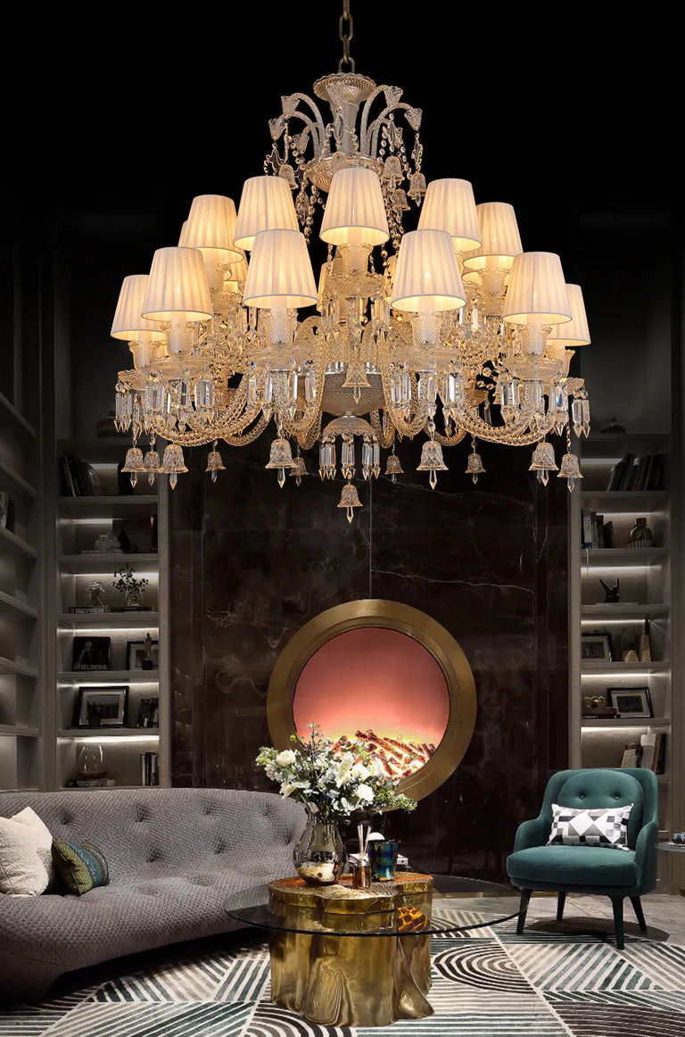 Luxurious chandelier hanging above a living room with a fireplace and decorative elements.