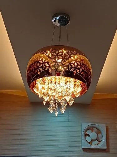Decorative ceiling light fixture with crystal details on a wooden floor.
