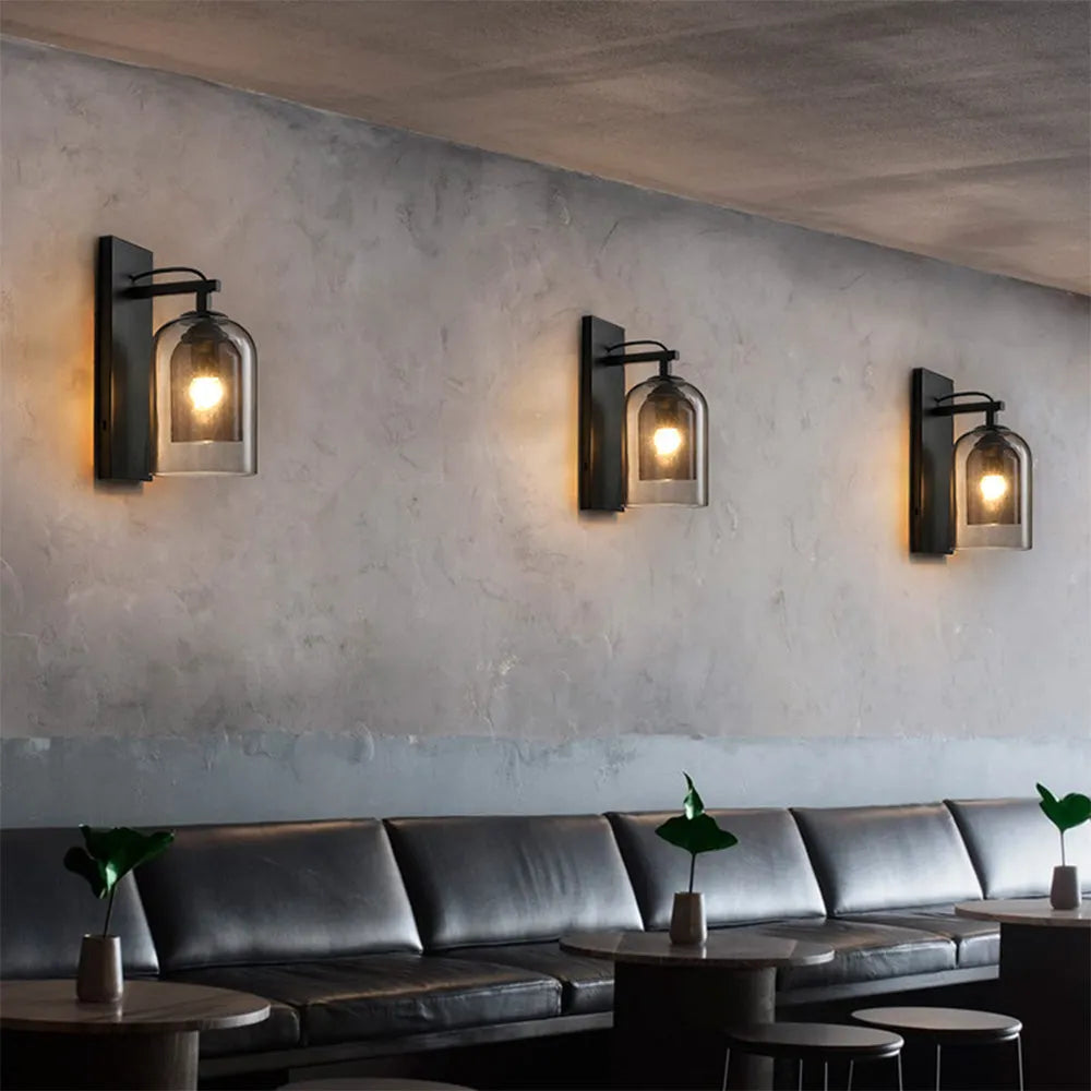 Three wall-mounted lights on a textured wall above a sofa in a modern interior setting.