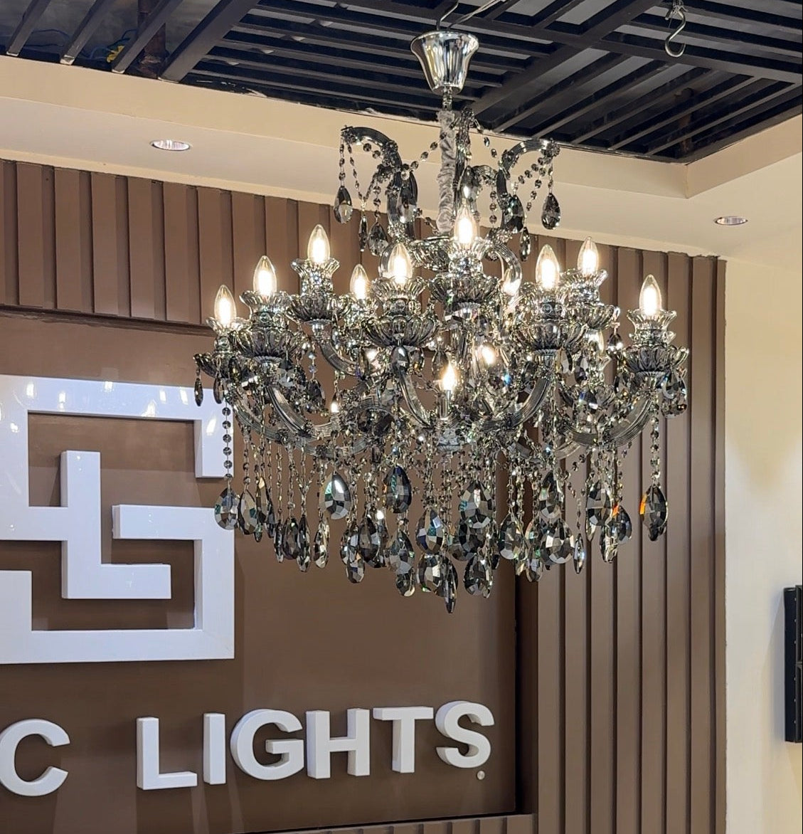 Chandelier hanging in a room with a sign that reads 'C Lights'.