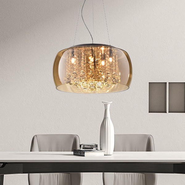 Modern pendant light hanging above a dining table with a vase on the table.