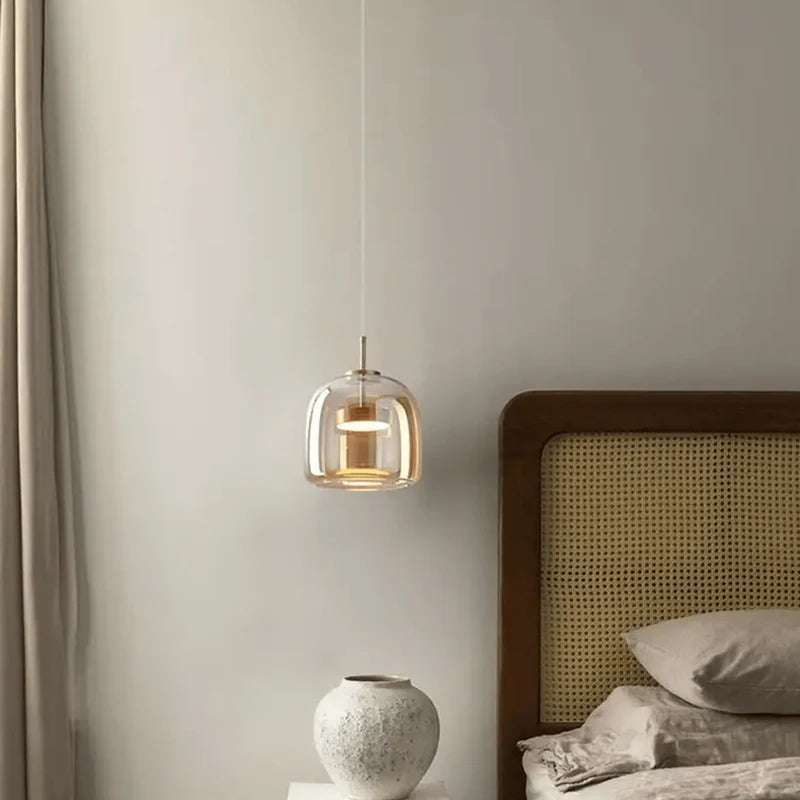 Modern pendant light fixture in a bedroom setting with a neutral color scheme.