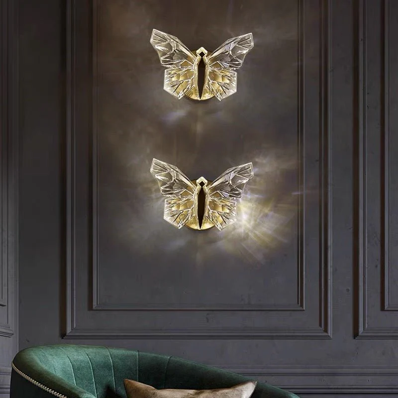 Two gold butterfly wall decorations on a dark paneled wall with a green chair in the foreground.