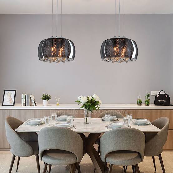 Dining room with modern pendant lights, table, and chairs.