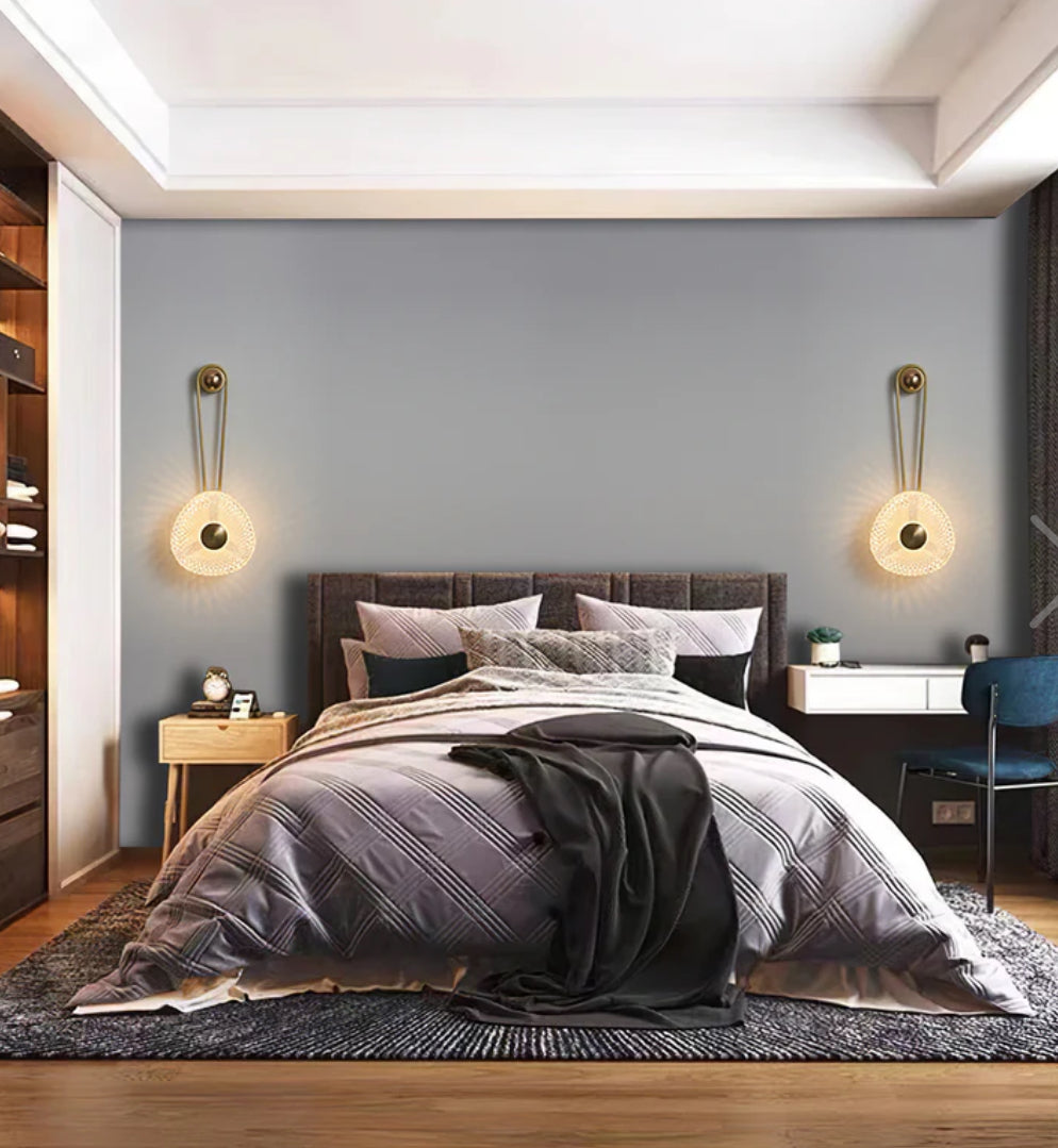 Modern bedroom with a bed, nightstands, and wall sconces.