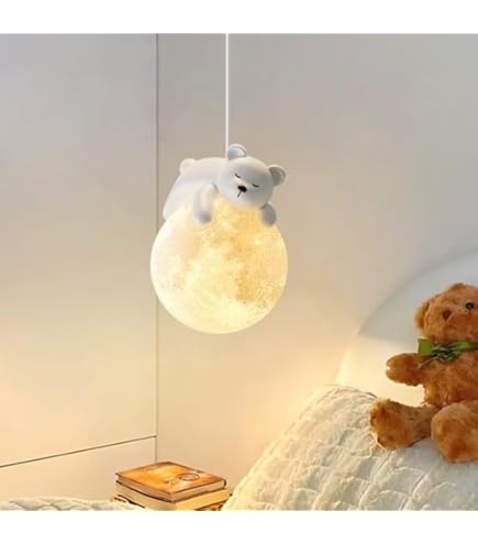 Lamp with a teddy bear design hanging above a bed with another teddy bear.