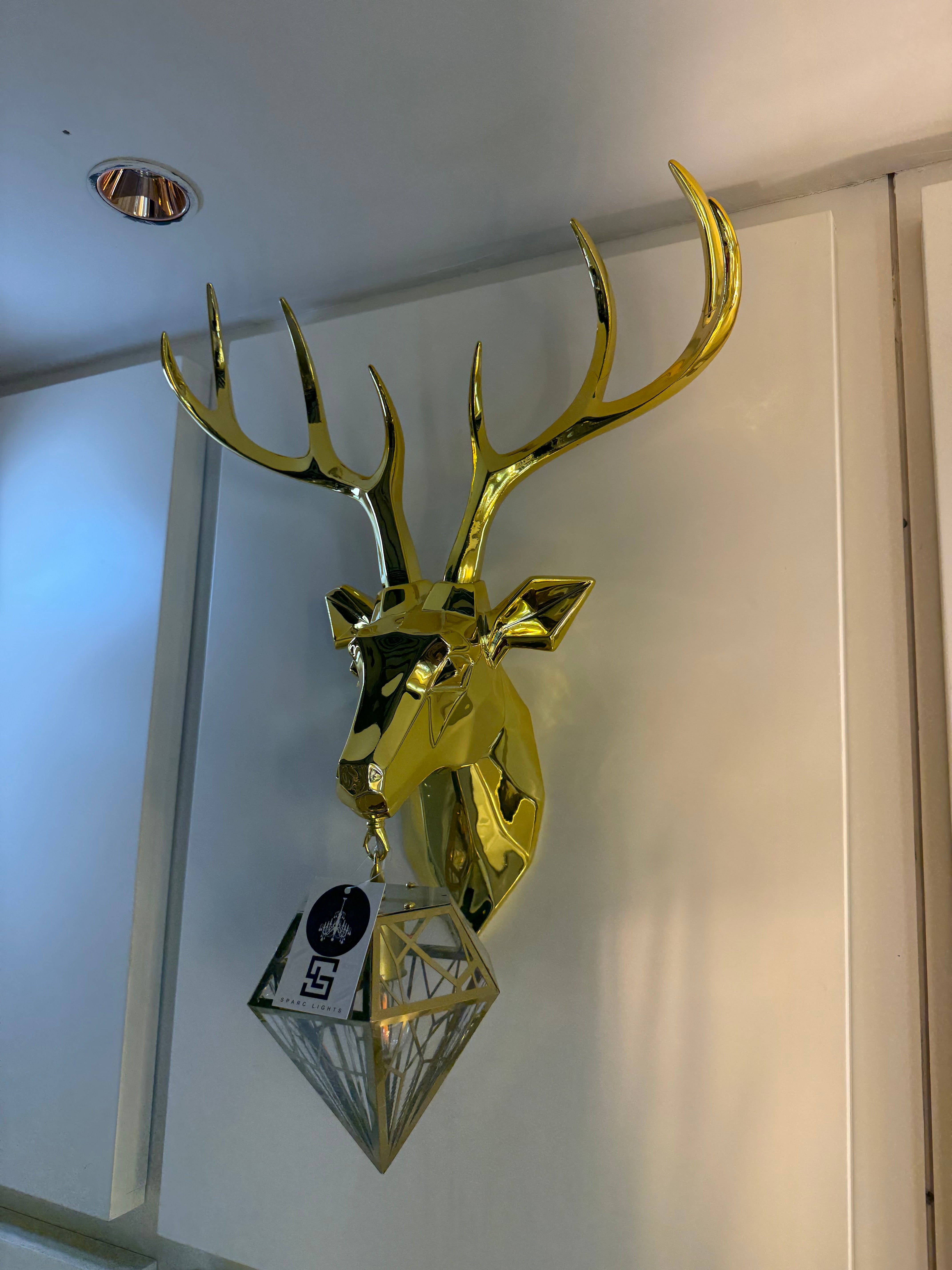 Gold deer head mount on a white wall