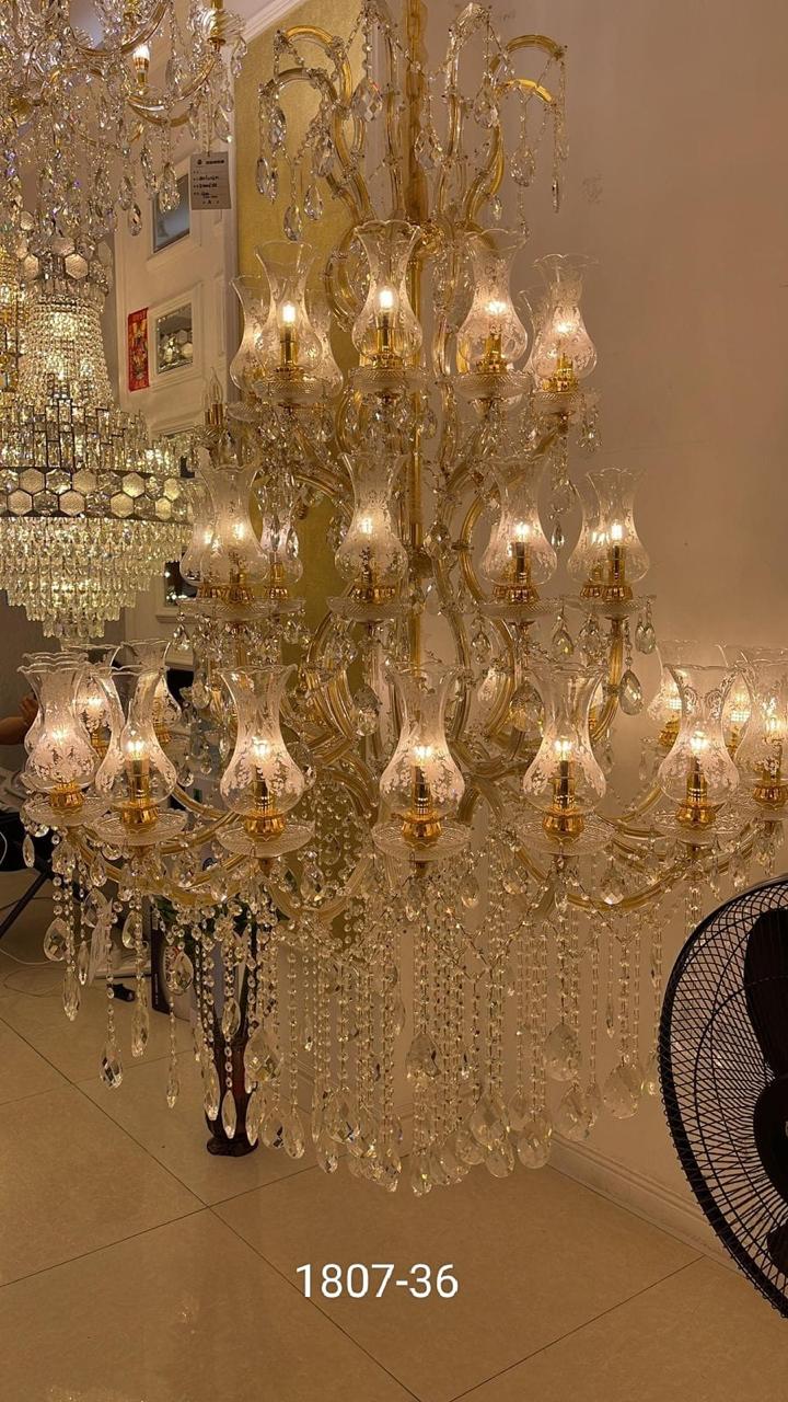 A gold-colored metal drip lamp chandelier with LED lights, featuring a luxurious design suitable for high ceilings and grand rooms.