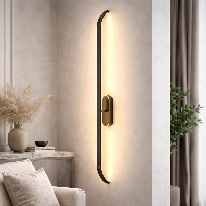 Modern wall sconce lighting fixture on a neutral wall with decor elements.