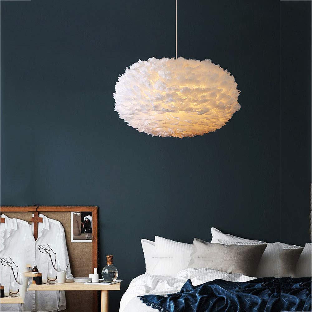 White feathered pendant light in a bedroom with dark walls and a bed.