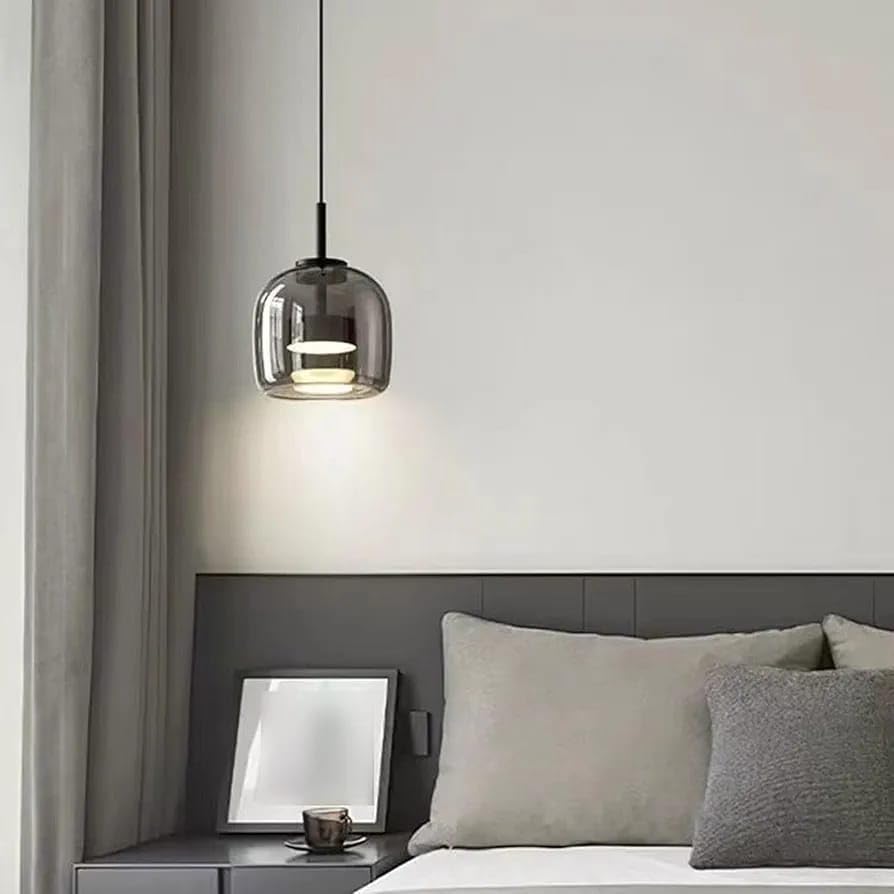 Modern bedroom with a pendant light, bed, and side table.