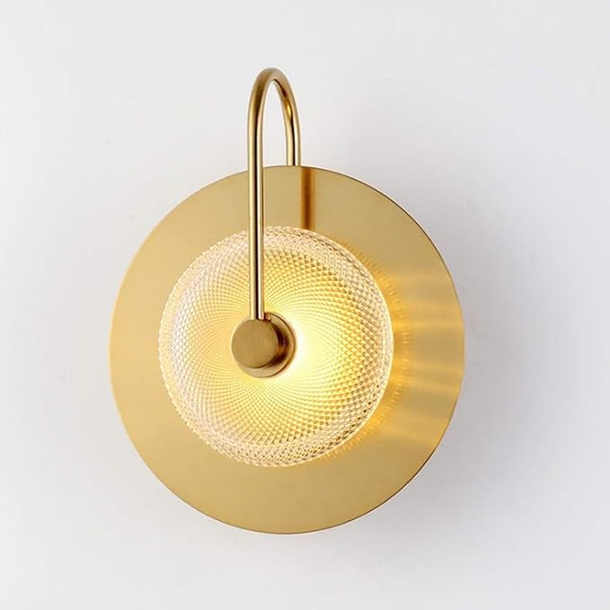 Gold wall sconce with a textured design on a white background