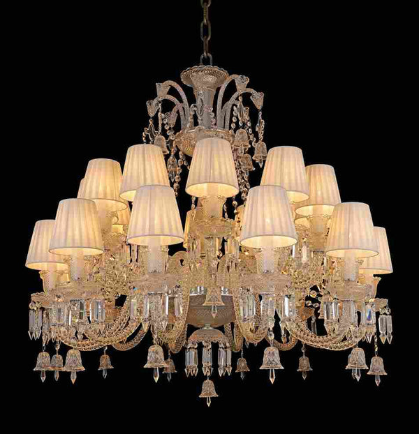 Decorative chandelier with crystal details and white lampshades on a black background