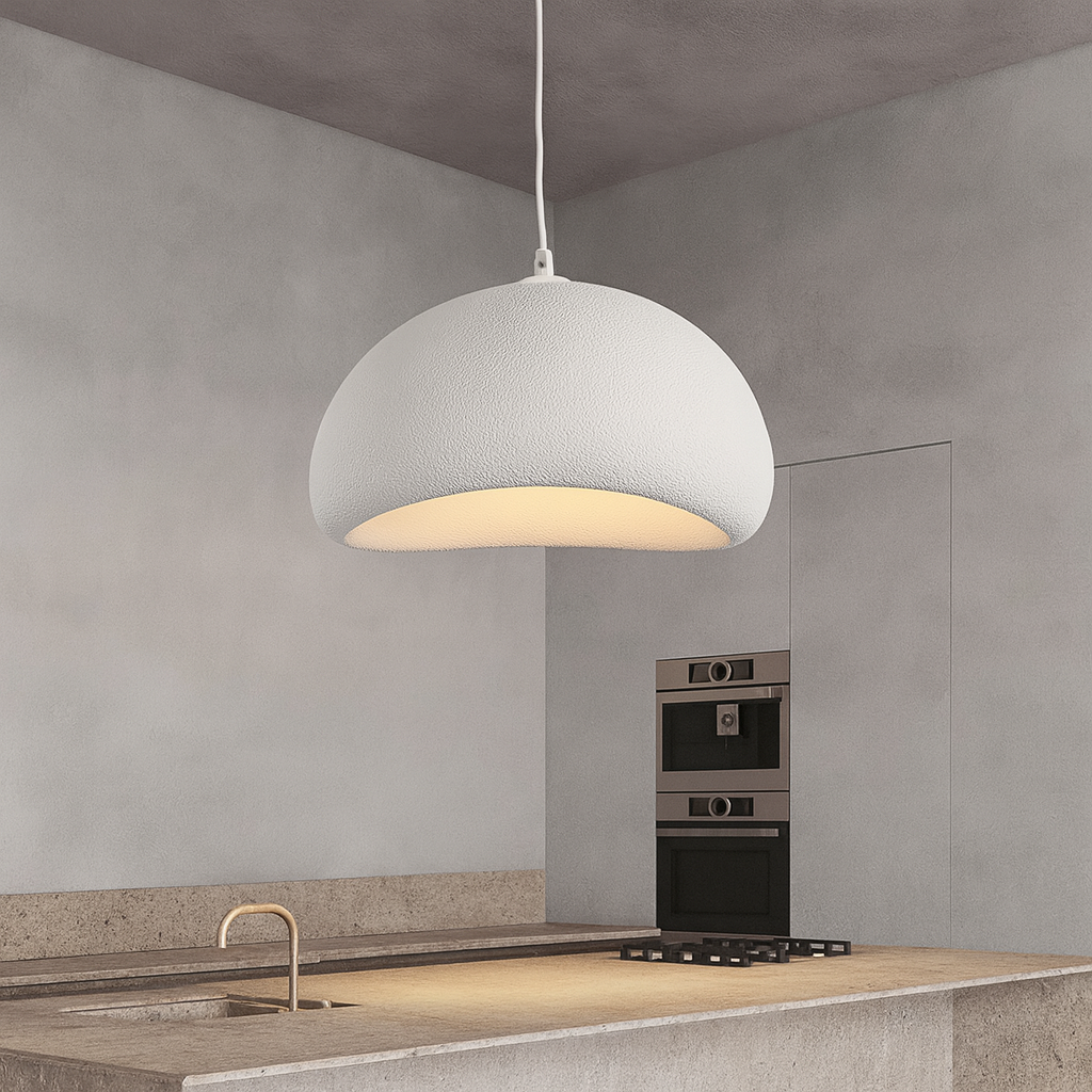 Modern pendant light hanging above a kitchen counter with a neutral color scheme.
