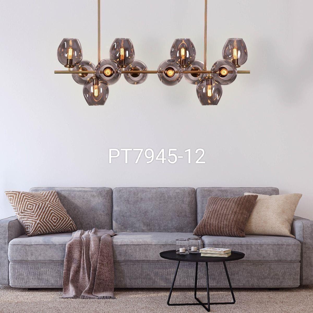 A modern chandelier with gold metal and LED lights, hanging over a gray sofa in a living room setting.