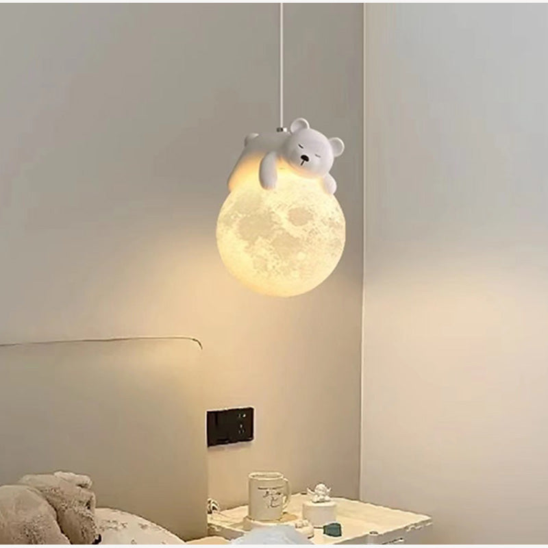 Ceiling light fixture with a bear design hanging from a moon-shaped lampshade in a bedroom setting.