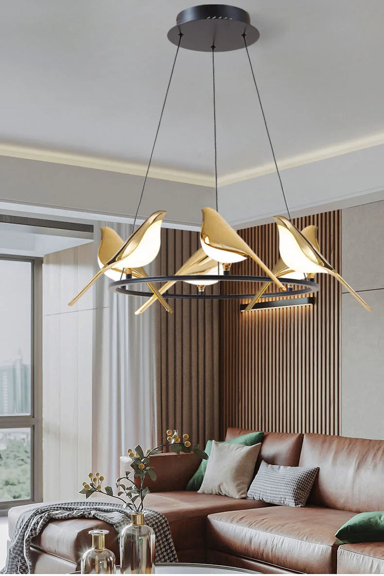 Modern chandelier hanging above a living room with a brown sofa and decorative pillows.