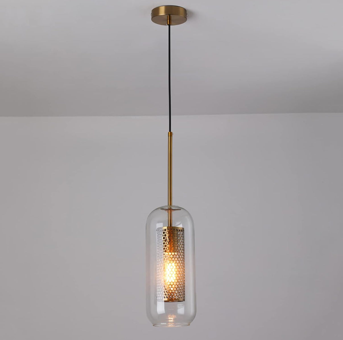 Pendant light with glass shade and gold fixture on a plain background