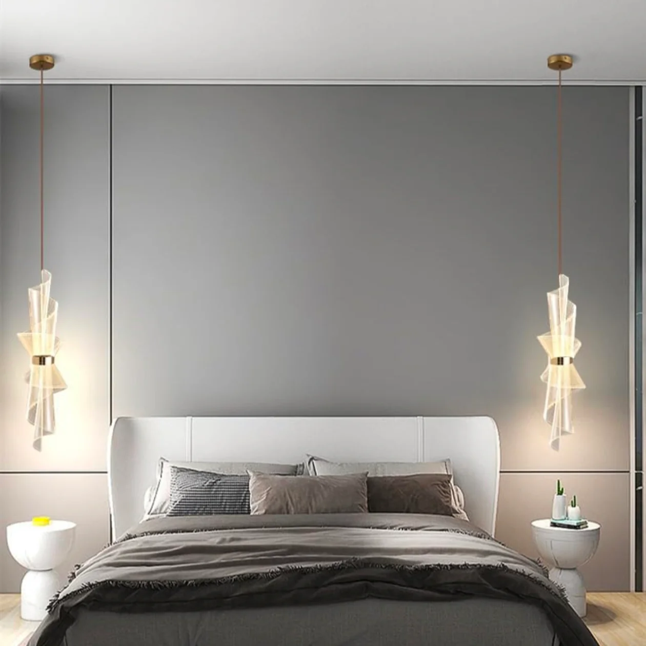 Modern bedroom with a bed, nightstands, and pendant lights against a gray wall.