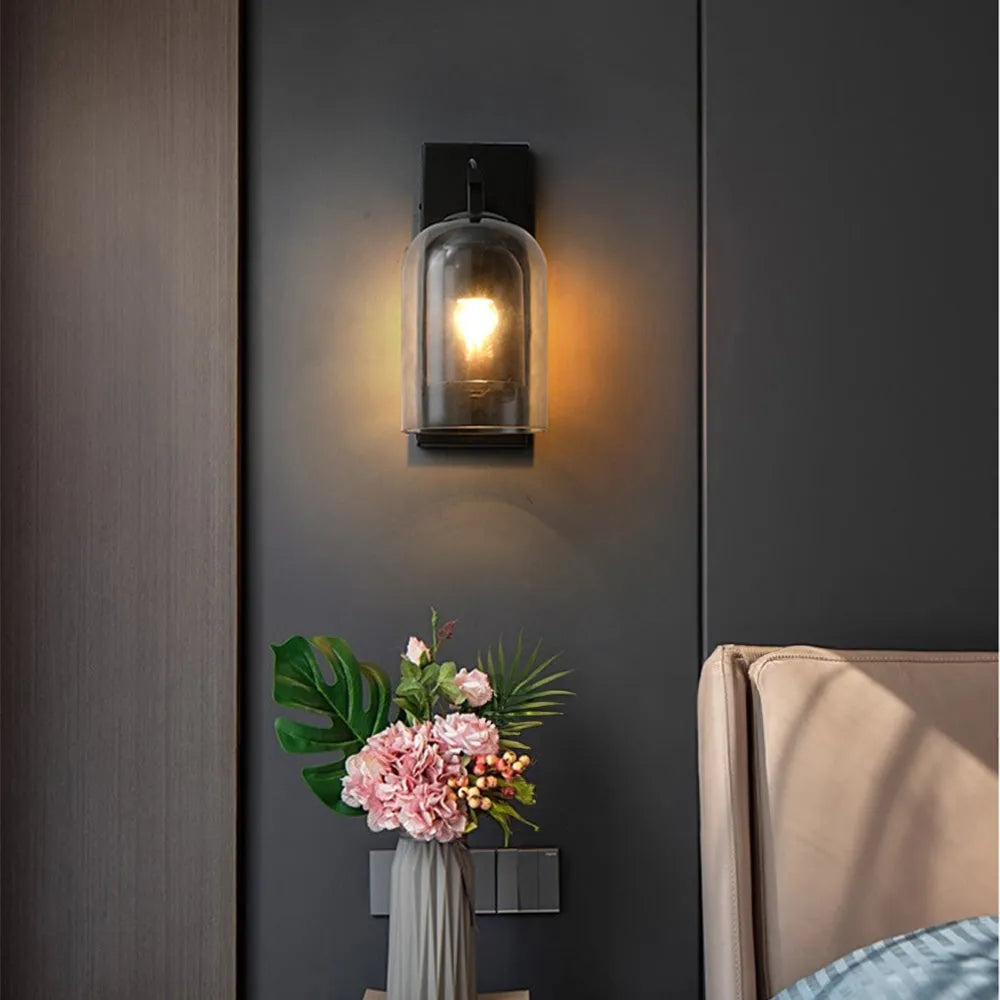 Wall sconce with a floral arrangement on a dark wall.