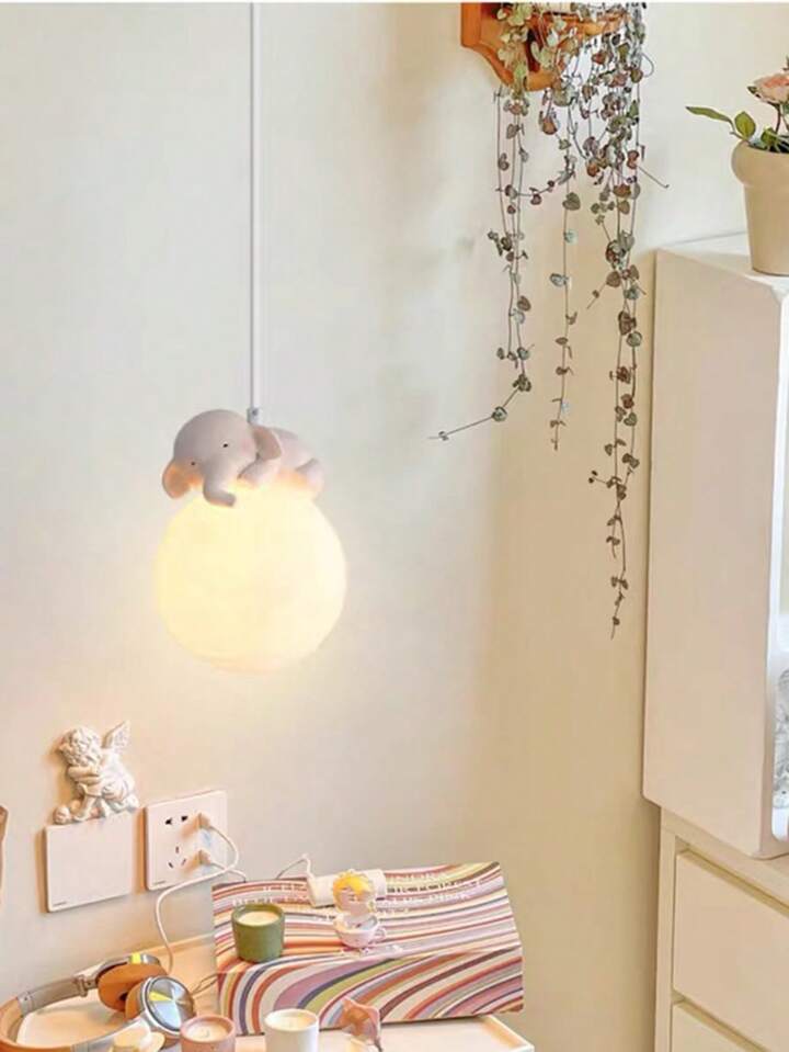 Children's room with a hanging lamp, colorful blanket, and toys on a bed.