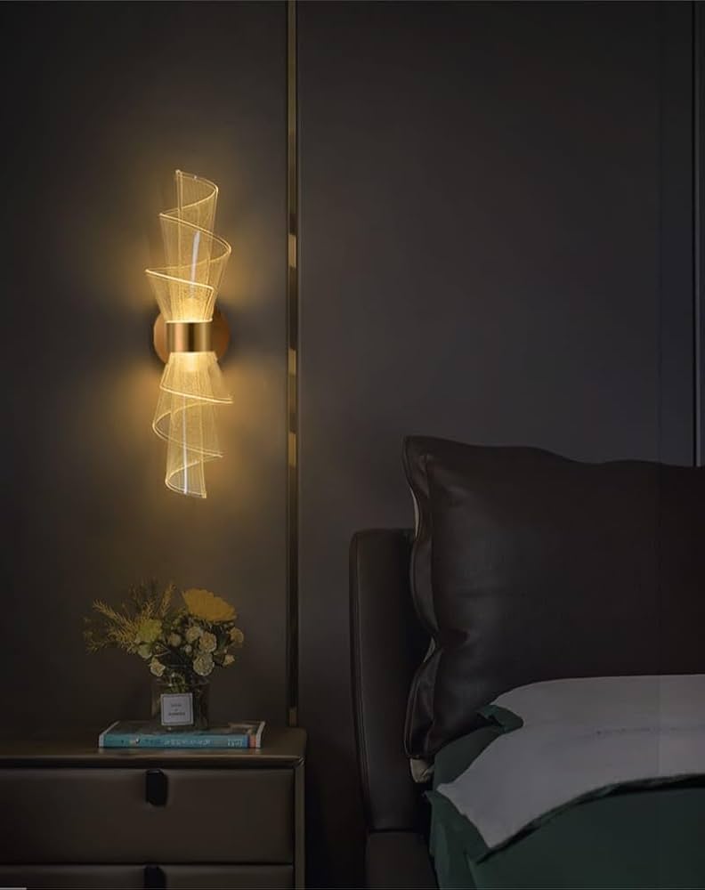 Decorative wall light fixture in a bedroom setting with a dark wall and bed.