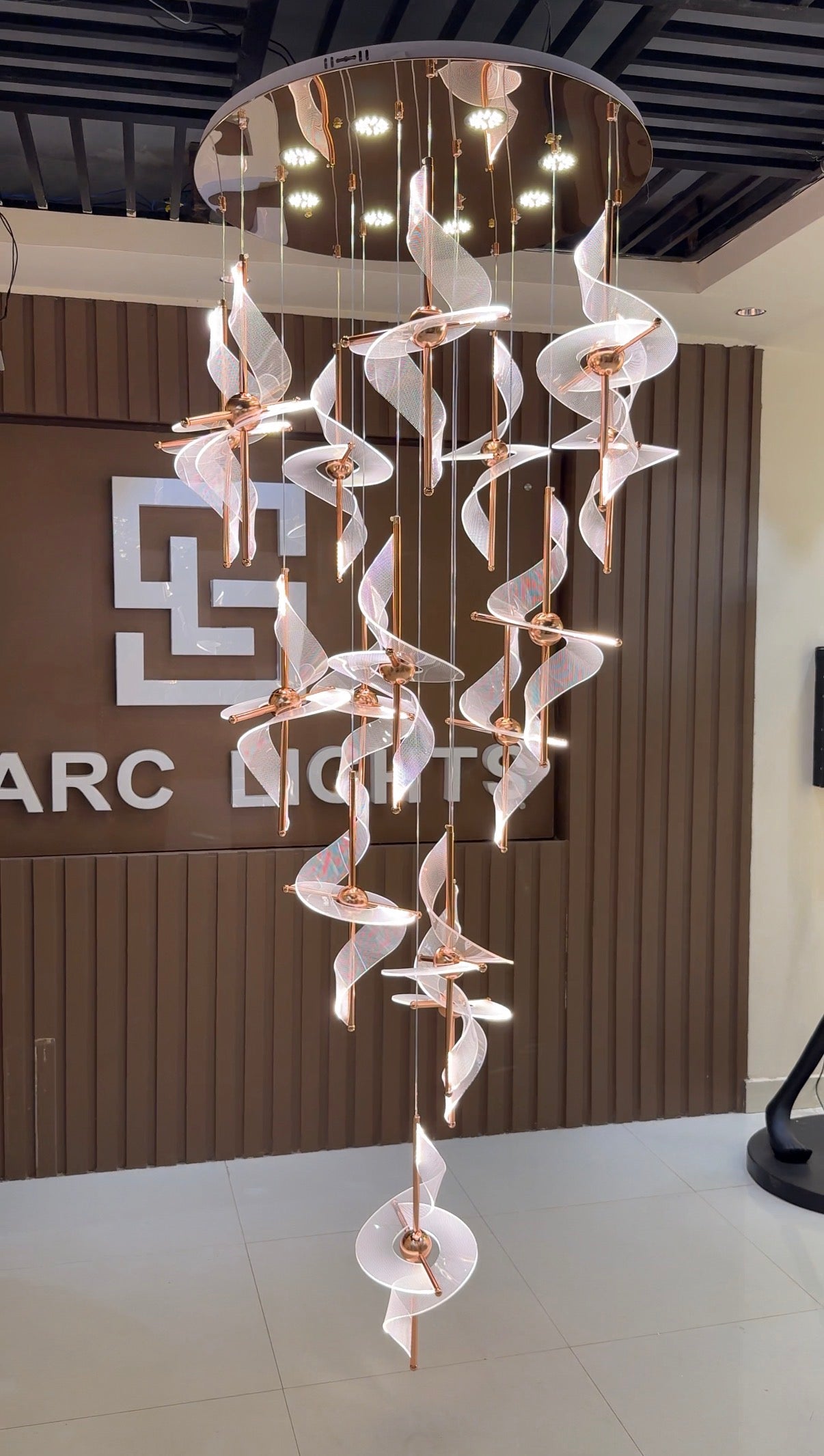 Modern chandelier with a brand logo in the background