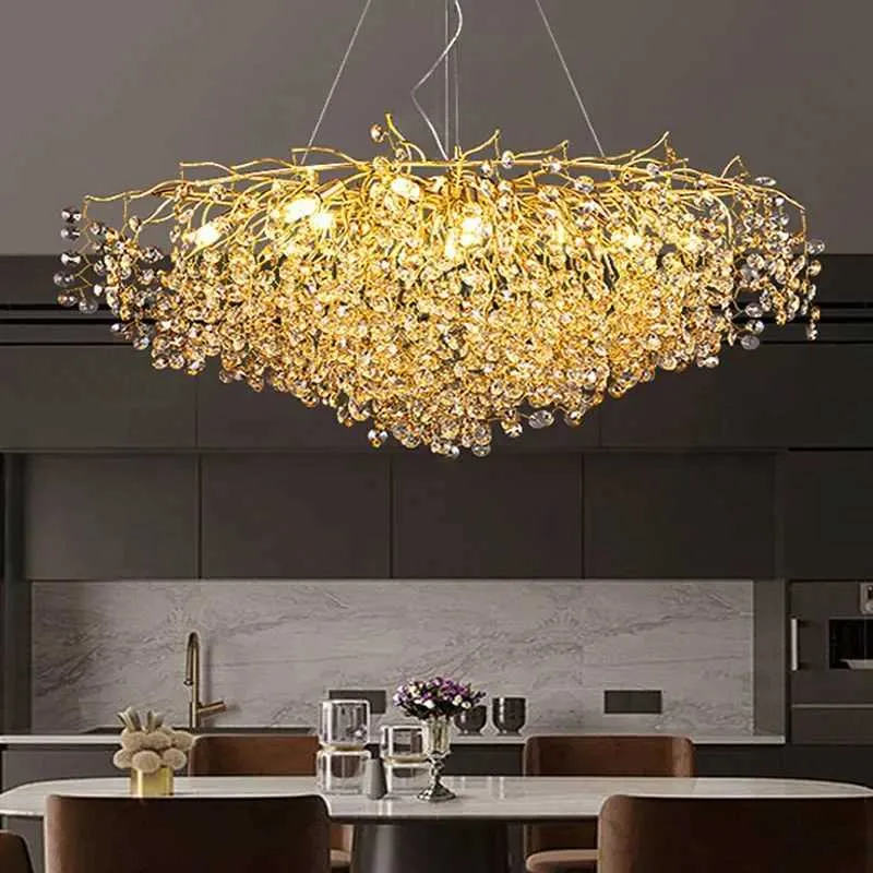 Gold chandelier hanging in a modern kitchen with marble countertops and dark cabinets.