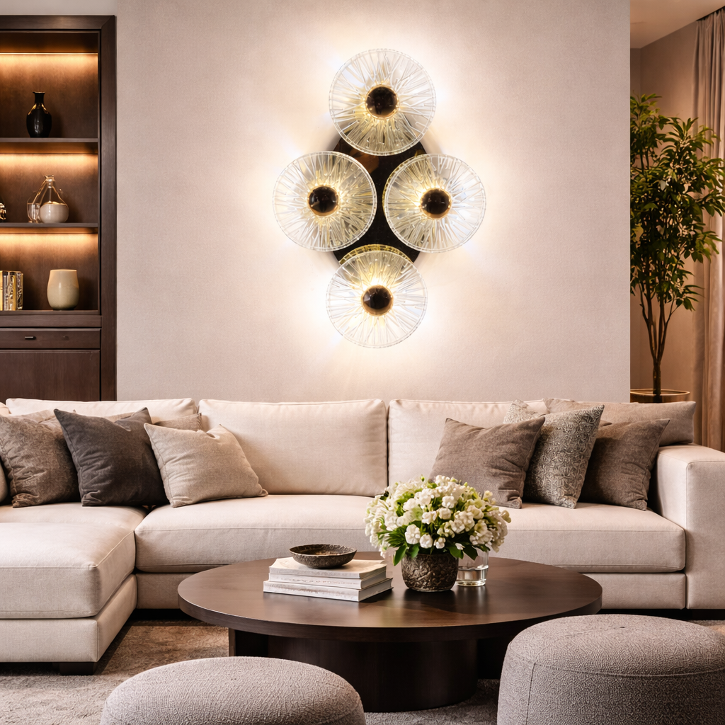 Modern living room with a beige sectional sofa, decorative pillows, a coffee table with a vase of flowers, and wall lights.