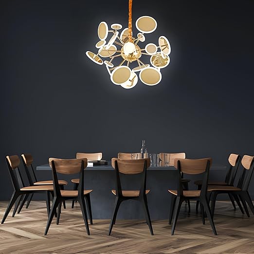 Modern dining room with a chandelier, table, and chairs against a dark wall.