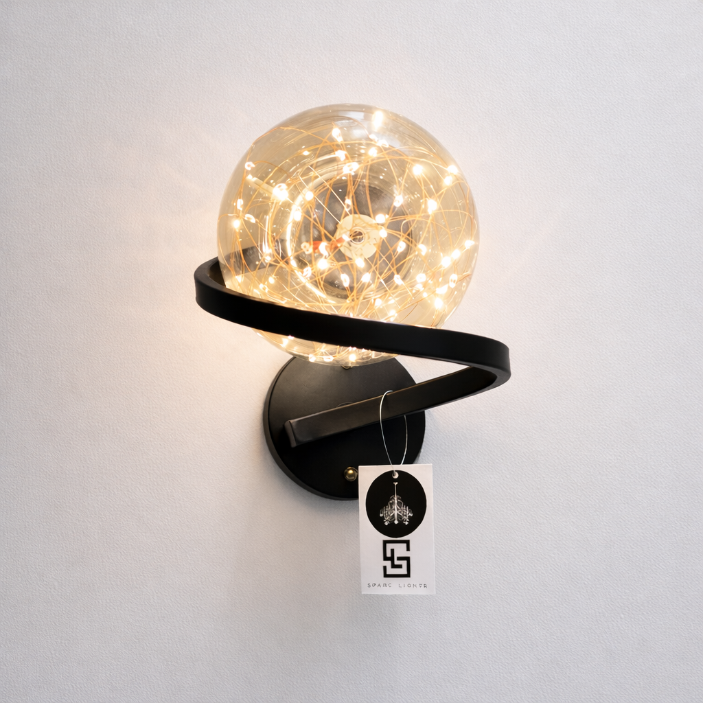 Wall-mounted lamp with a glass globe and black metal arm on a white wall, featuring a brand tag.