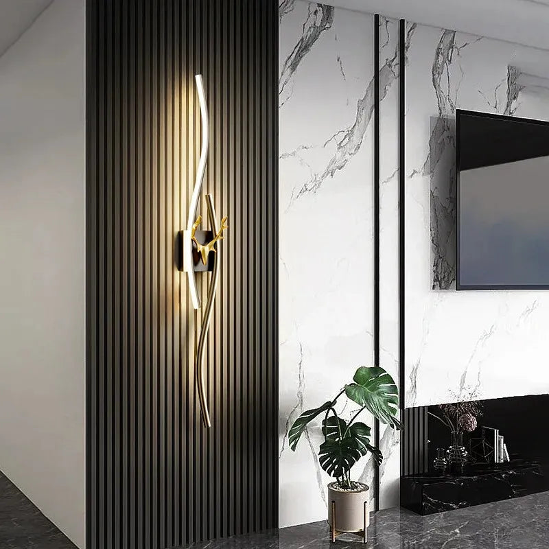 Modern wall light fixture in a stylish interior setting with marble walls and a plant.