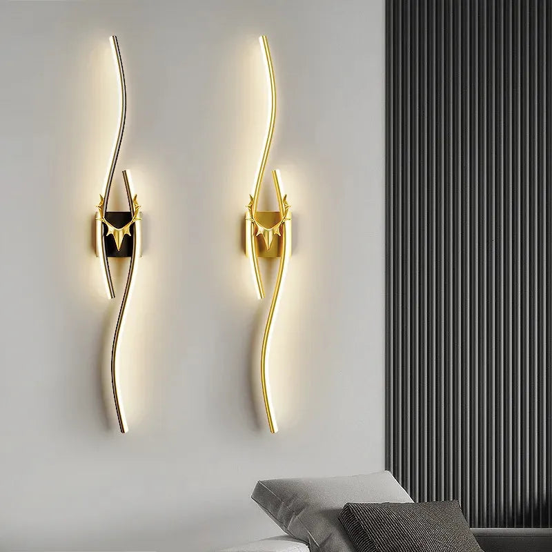 Gold wall sconces on a white wall with a black radiator.