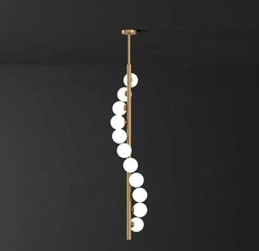 Modern pendant light with spherical glass shades on a dark background