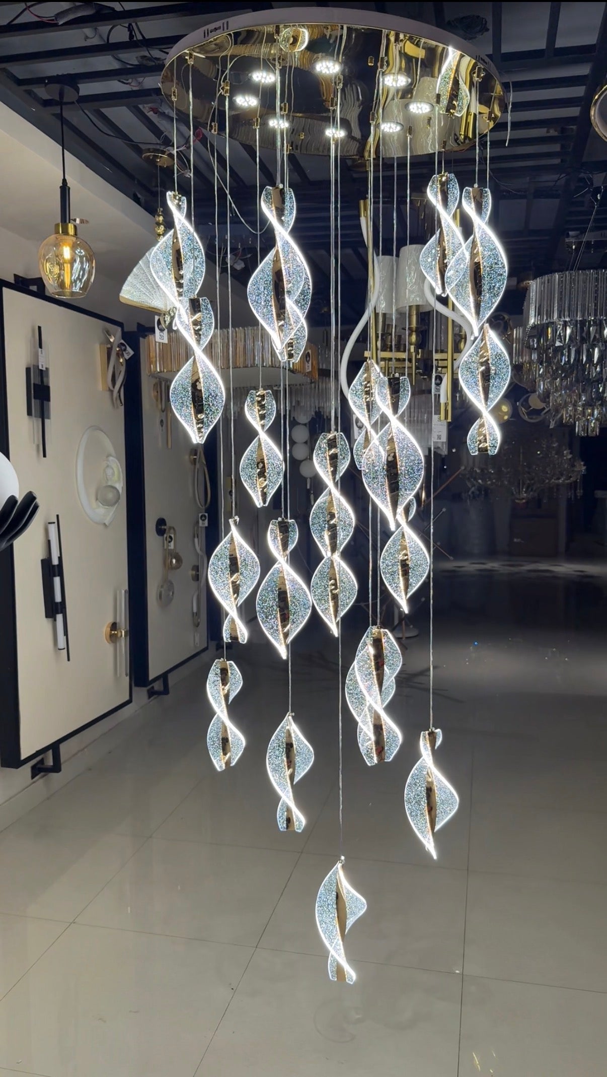 Modern chandelier with swirling design in a showroom setting