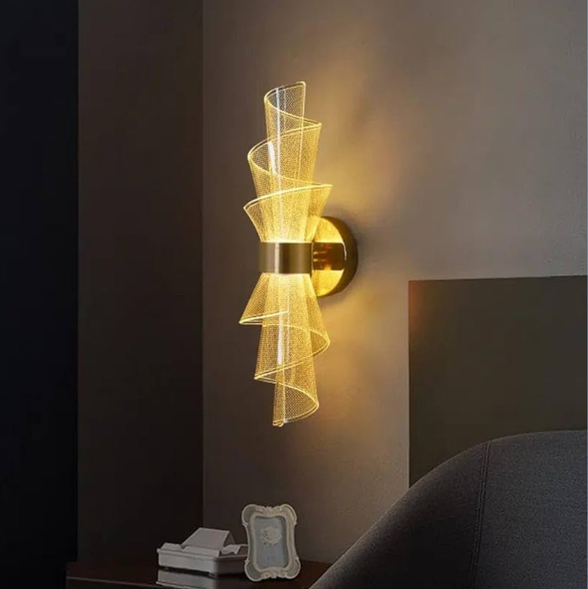 Decorative wall sconce with gold finish and ribbed glass shade on a dark wall.