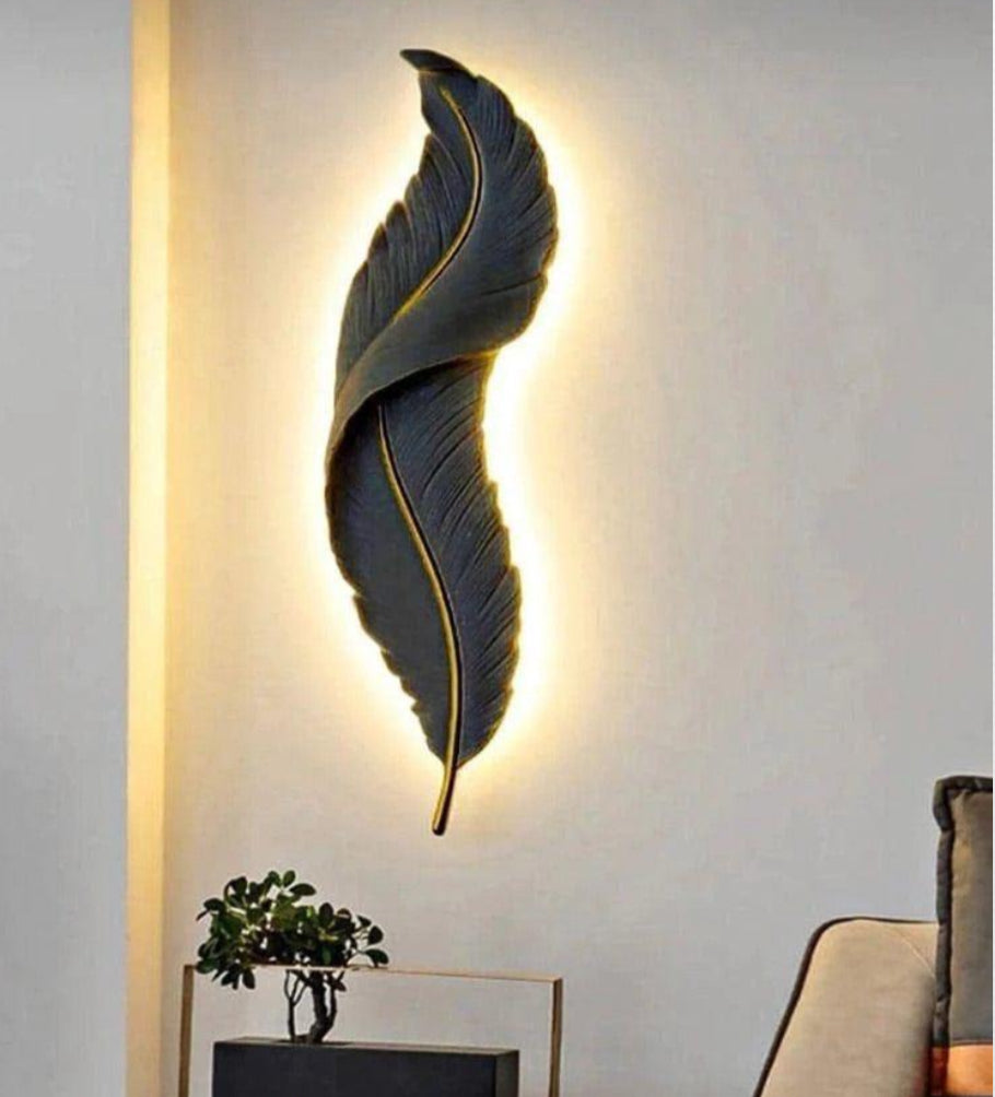Decorative wall light shaped like a feather on a wall with soft lighting.
