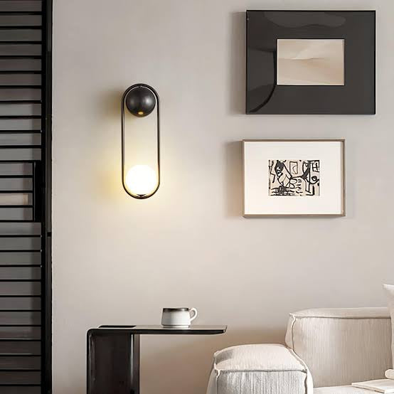 Modern wall sconce with framed artwork on a neutral wall.