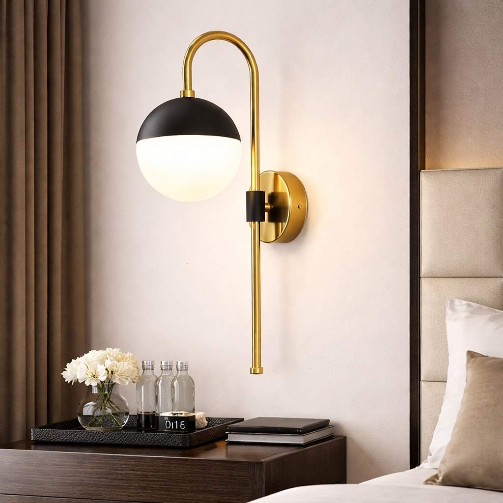 Modern wall sconce with black and gold design on a bedroom wall.