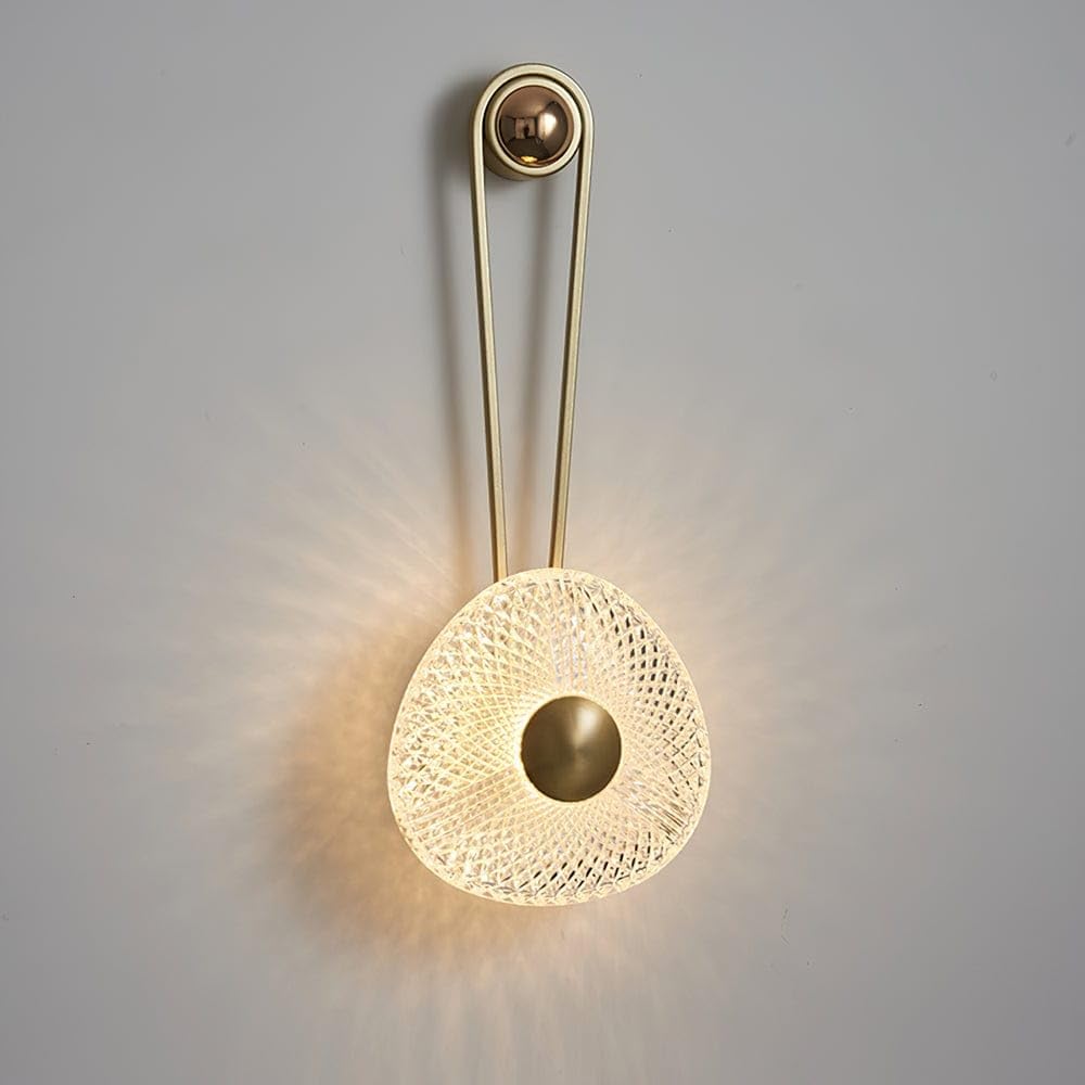 Wall-mounted lamp with gold finish and textured glass shade on a gray background